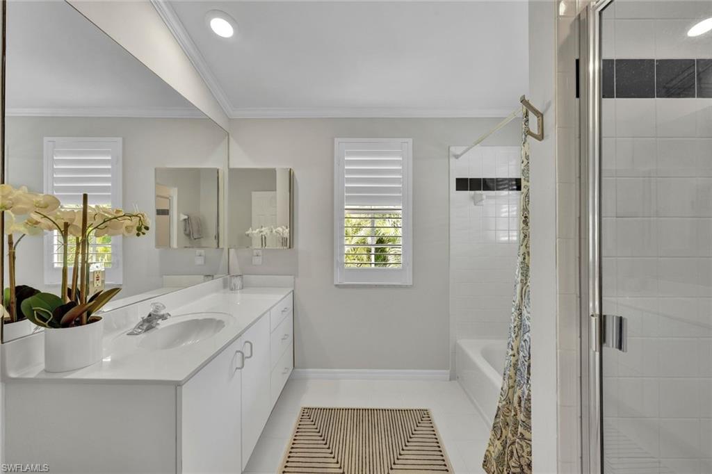 Bathroom featuring independent shower and bath, ornamental molding, tile patterned floors, and vanity