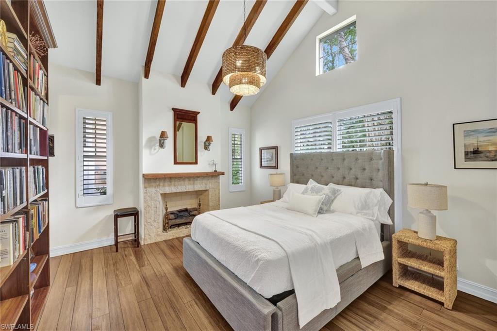 Bedroom featuring beam ceiling, light hardwood / wood-style flooring, and high vaulted ceiling