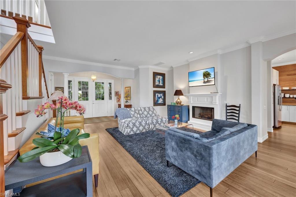Living room with ornate columns, ornamental molding, and light hardwood / wood-style floors