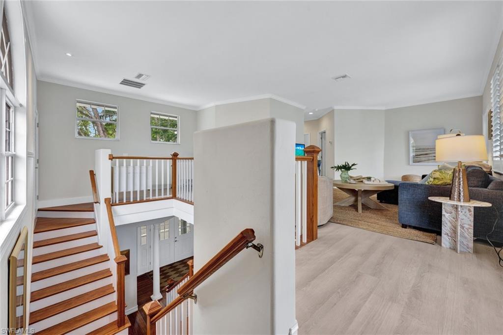 Hallway featuring crown molding and light hardwood / wood-style flooring