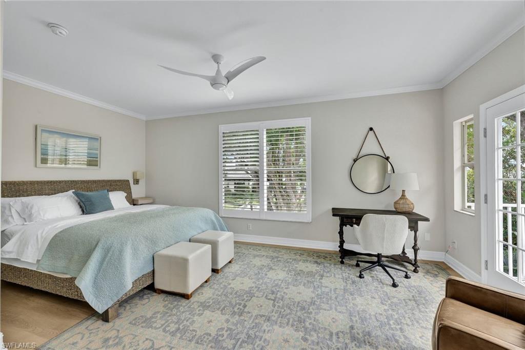 Bedroom with ceiling fan, ornamental molding, and hardwood / wood-style floors