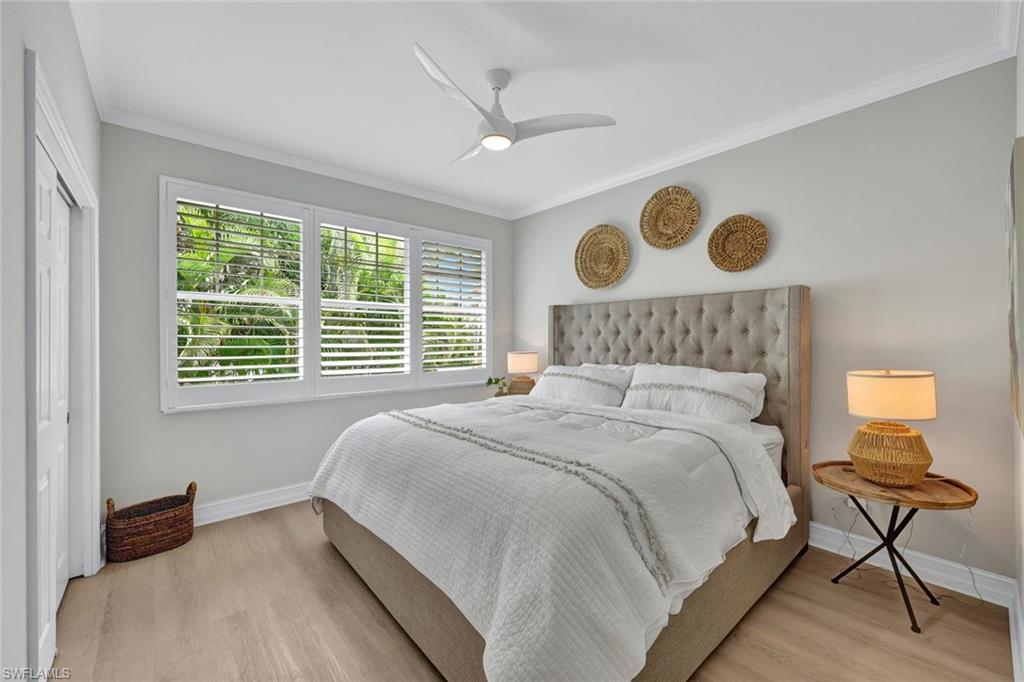 Bedroom featuring ceiling fan, crown molding, light hardwood / wood-style flooring, and a closet