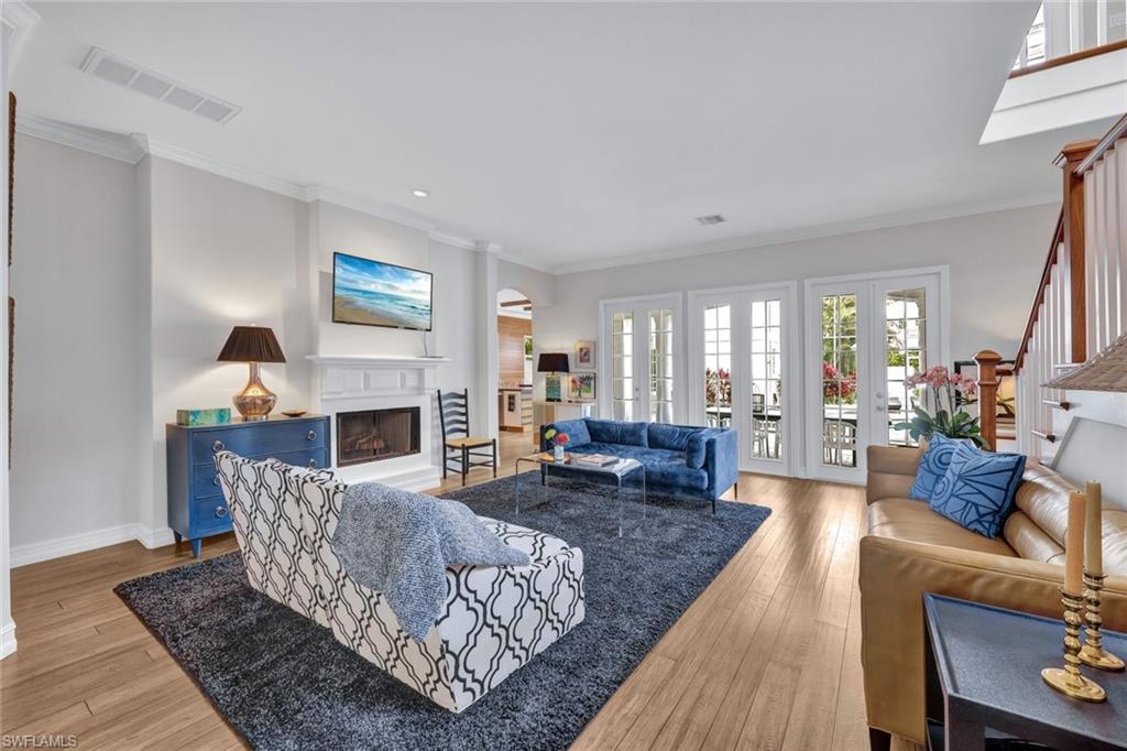 Living room with french doors, ornamental molding, and light hardwood / wood-style flooring