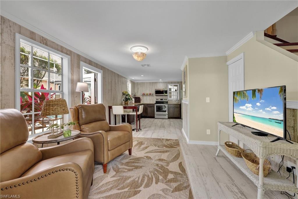 Living room featuring light wood-type flooring and ornamental molding