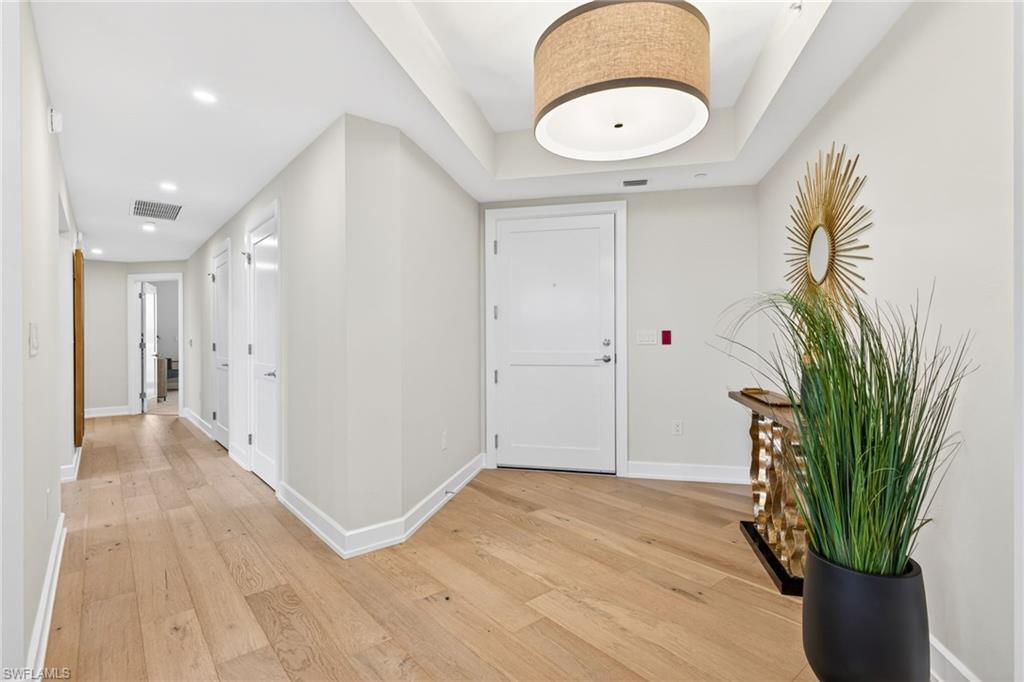 Large foyer entrance with light wood floors and recessed lighting
