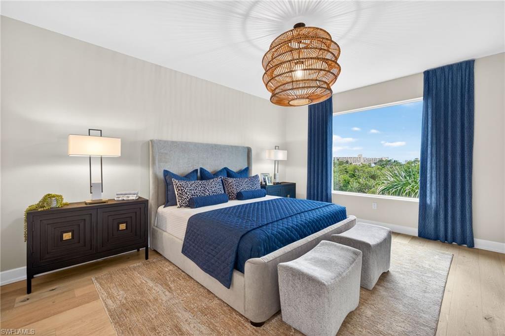 Master Suite featuring coastal contemporary decor , light wood-style floors and a pretty bamboo chandelier