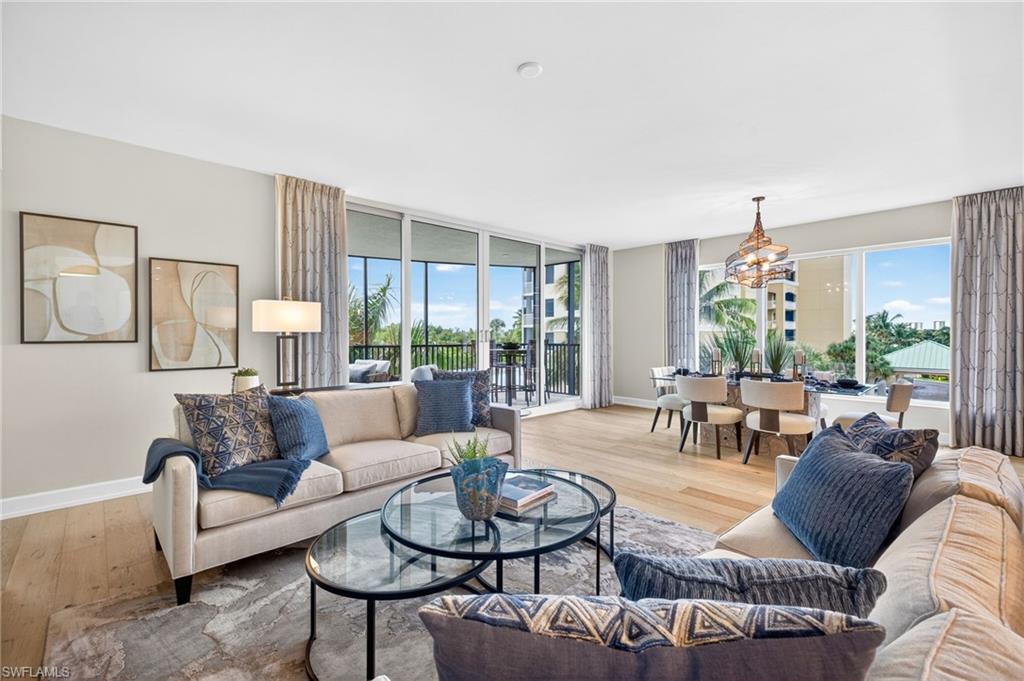 Living area with light wood-type flooring, floor to ceiling windows, healthy amount of natural light streams through the large sliding glass terrace doors