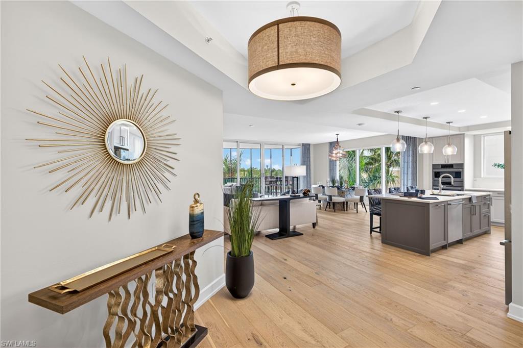 Large inviting entryway with a tray ceiling and light wood flooring
