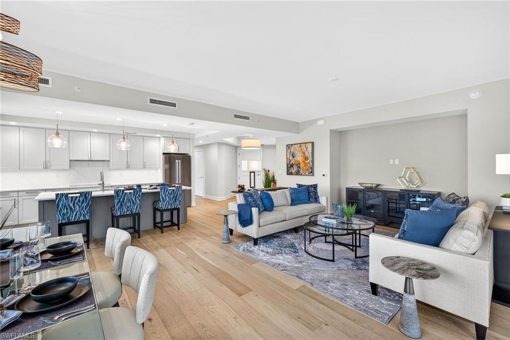 Living room, dining room and kitchen featuring coastal contemporary decor , recessed lighting and light wood-style floors