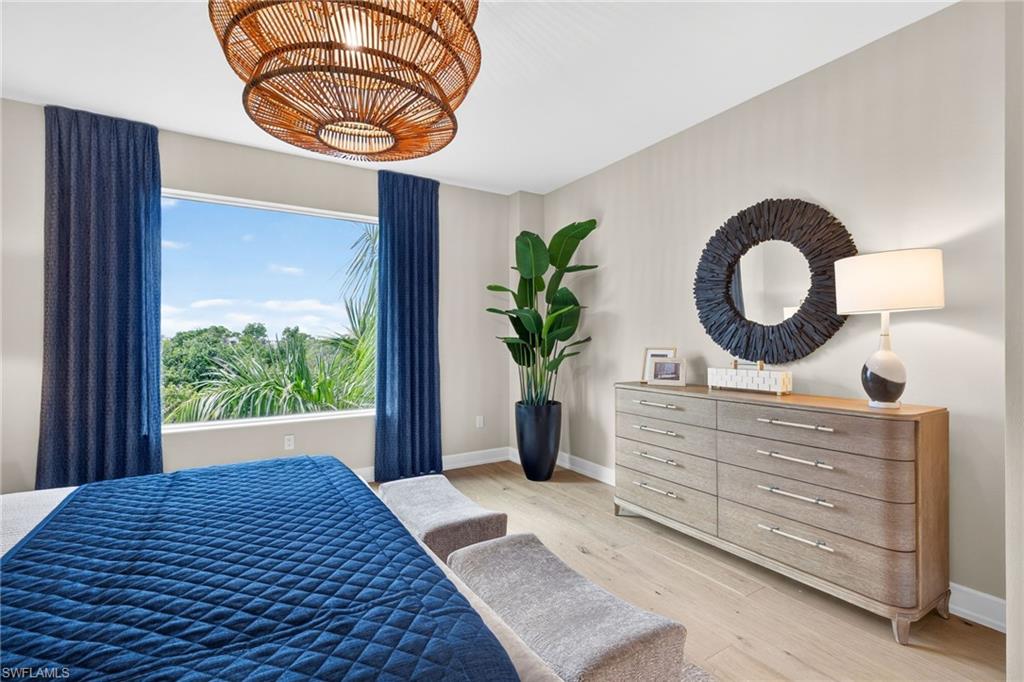 Master Suite with large window gives views of tropical palm trees and florida mangroves