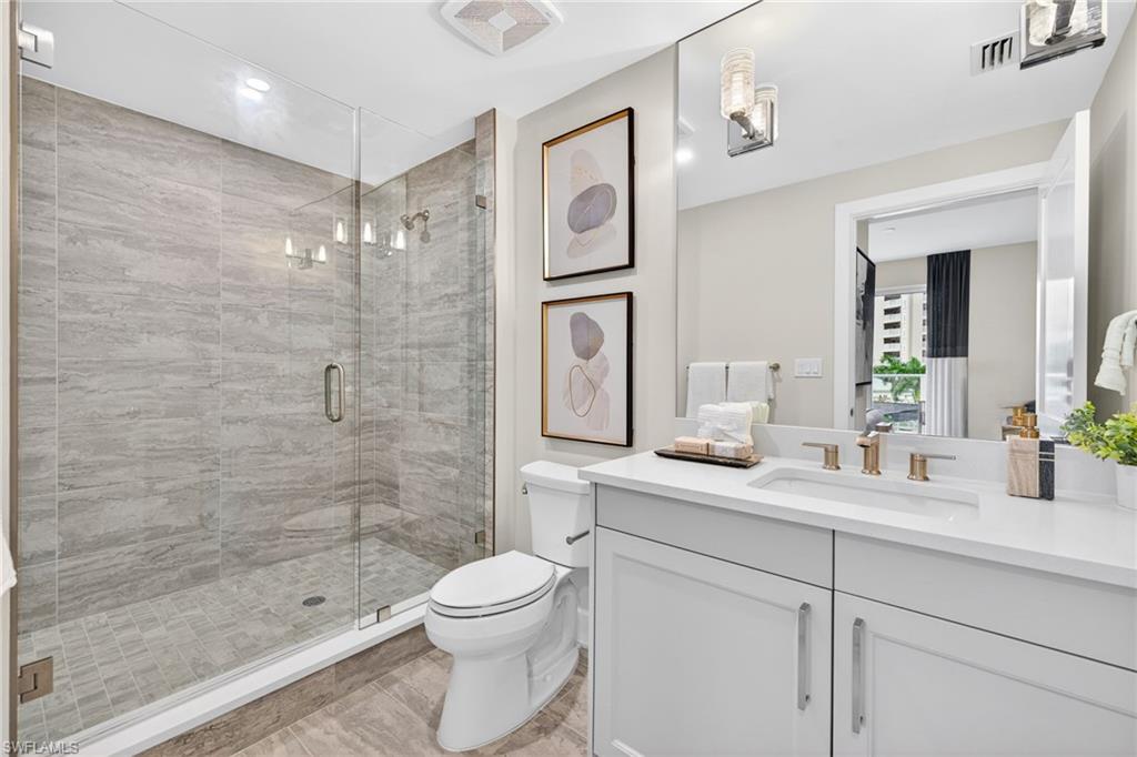 Bathroom 2 with beautiful tiled shower and tile flooring, sleek vanity and stone counter