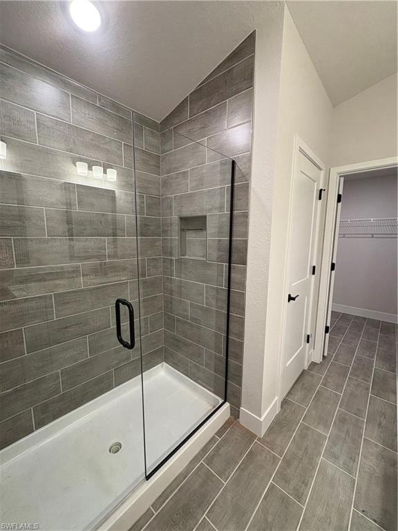 Full bath with a shower stall and a spacious closet
