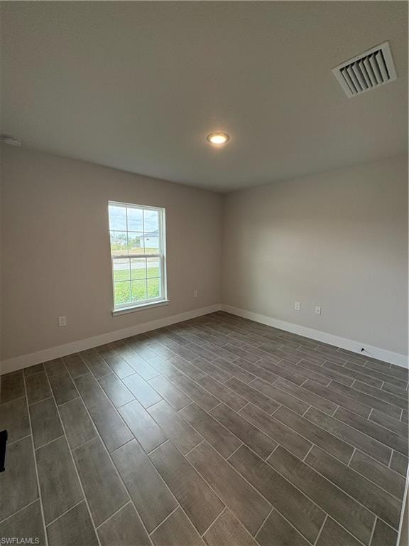 Empty room featuring recessed lighting and wood tiled floors
