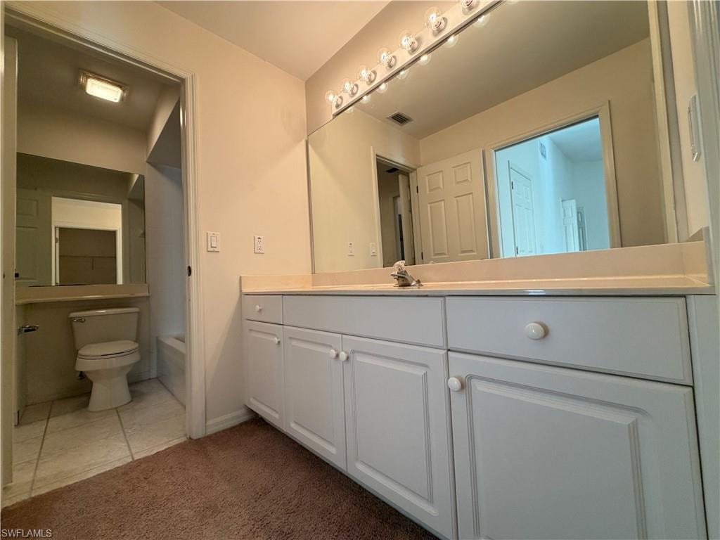 Bathroom with vanity, dark carpet, bathing tub / shower combination, and dark tile patterned floors
