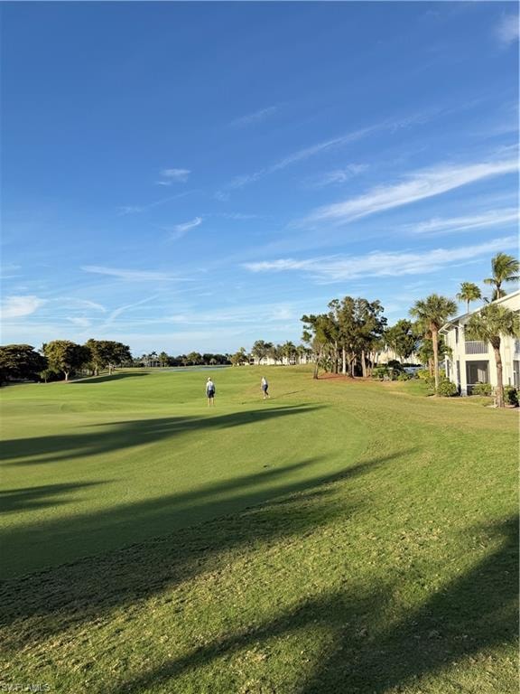 View of property's community with view of golf course and a yard