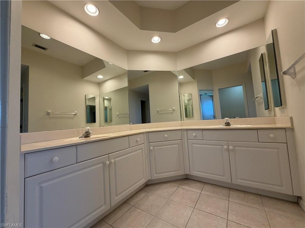 Bathroom with double vanity, light tile patterned floors, and recessed lighting