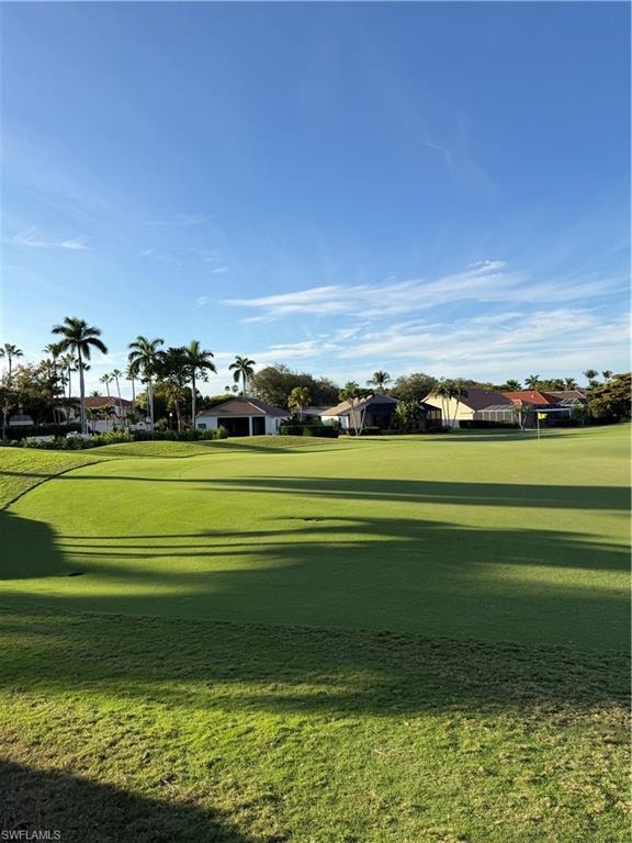 View of community with a lawn, view of golf course, and a residential view