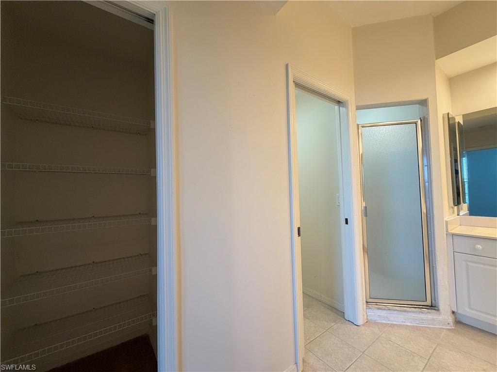Bathroom featuring vanity, a stall shower, and light tile patterned flooring