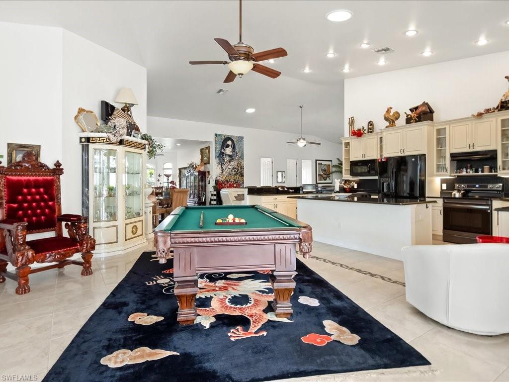 Game room with lofted ceiling, ceiling fan, billiards table, light tile patterned floors, and recessed lighting