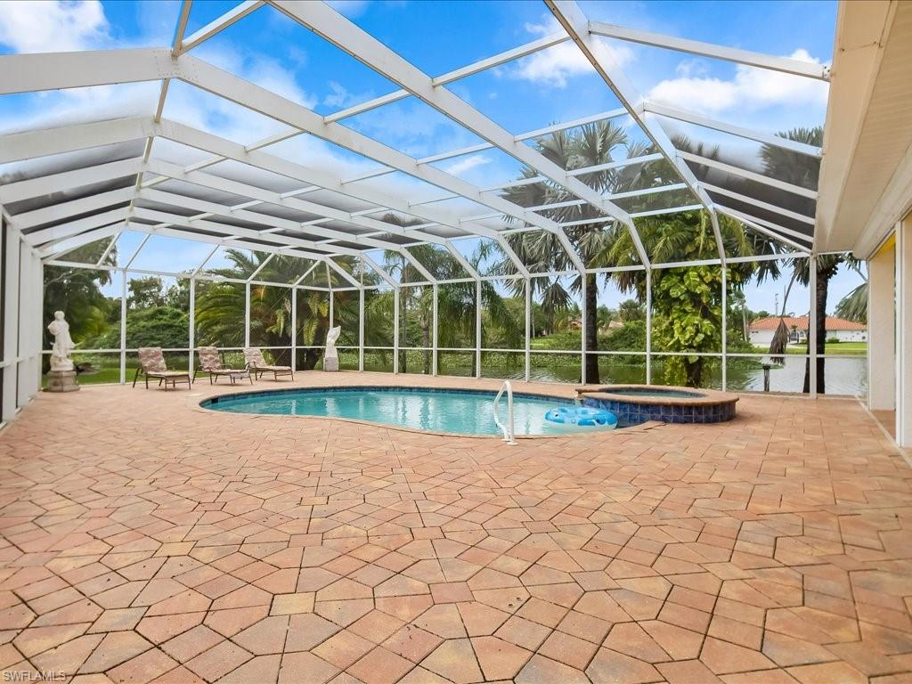 View of swimming pool featuring a patio area, a sunroom, glass enclosure, and a pool with connected hot tub