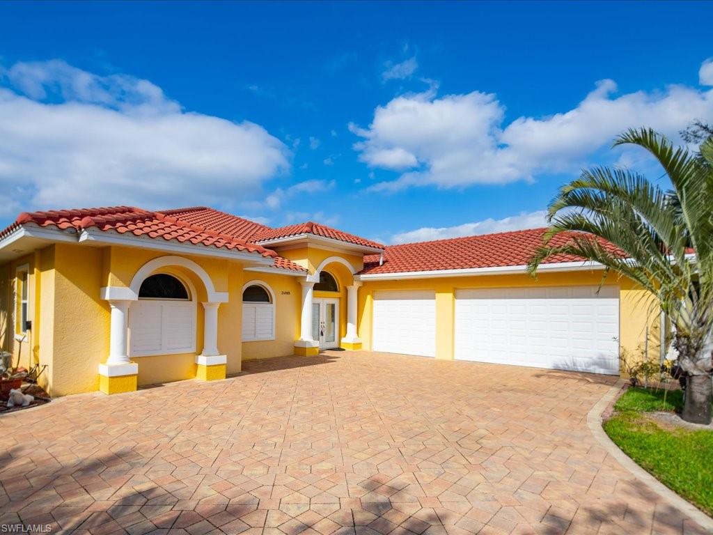 Mediterranean / spanish home featuring stucco siding, decorative driveway, a garage, and a tiled roof