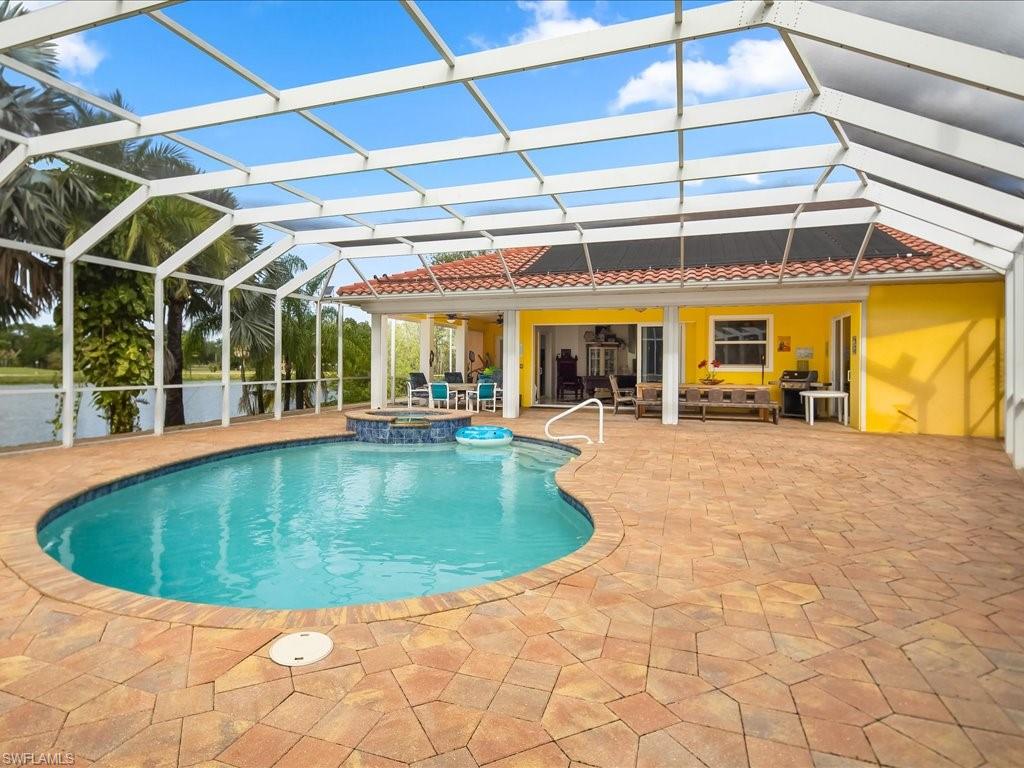 View of swimming pool featuring a patio, a sunroom, a lanai, and a pool with connected hot tub