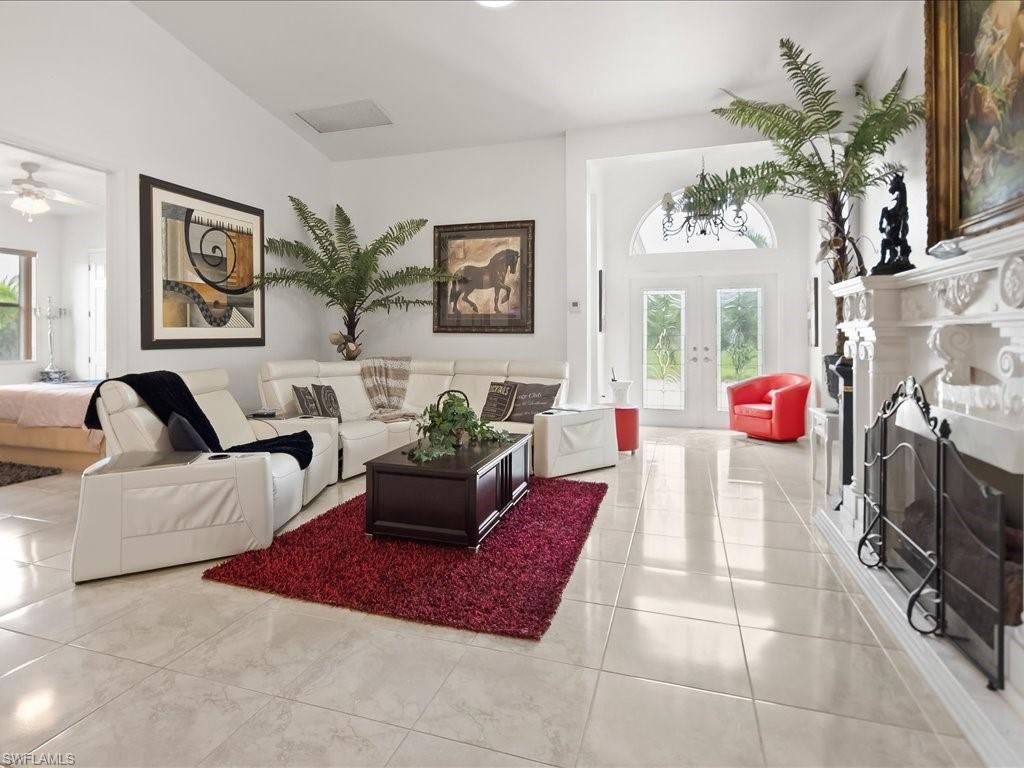 Living room featuring french doors, a fireplace, plenty of natural light, and tile patterned floors