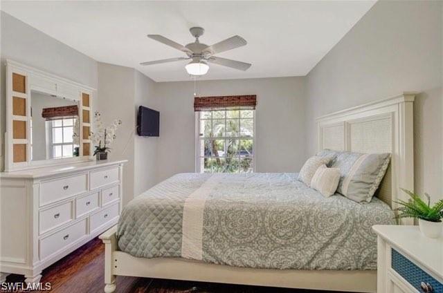 Bedroom with dark wood-style flooring and a ceiling fan