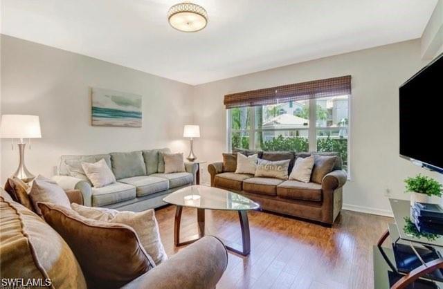 Living room featuring hardwood / wood-style flooring and baseboards