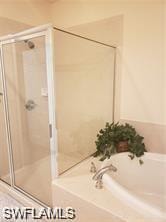 Full bathroom featuring a garden tub and a stall shower