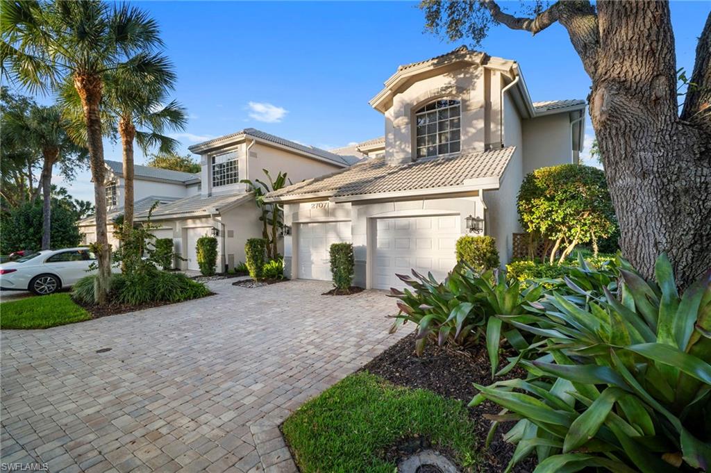 Mediterranean home with stucco siding, a tile roof, decorative driveway, and an attached garage