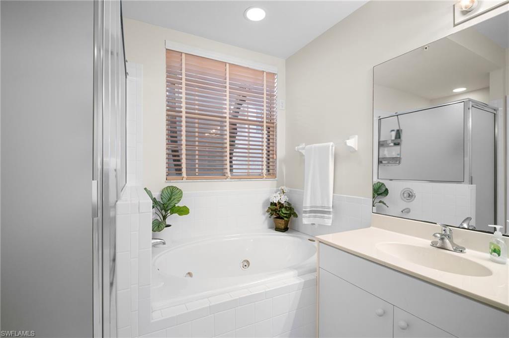 Bathroom featuring a whirlpool tub, vanity, a shower stall, and recessed lighting