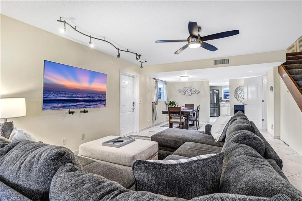 Living room featuring a ceiling fan and rail lighting
