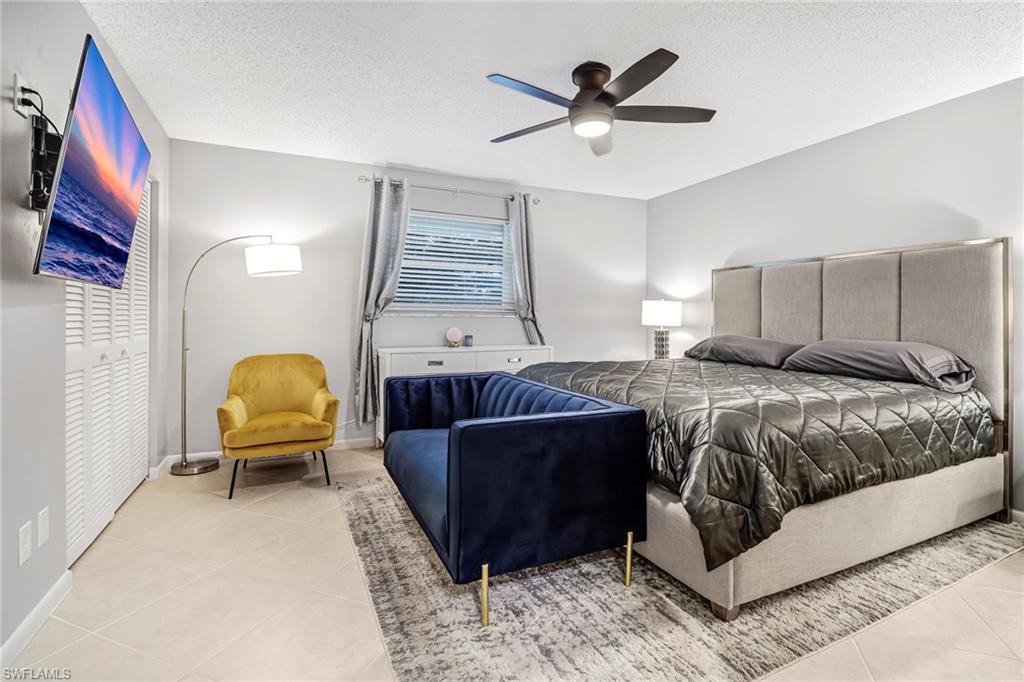 Tiled bedroom featuring a textured ceiling and a ceiling fan