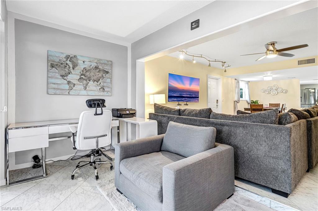 Living area with a desk, light marble finish flooring, a ceiling fan, and rail lighting