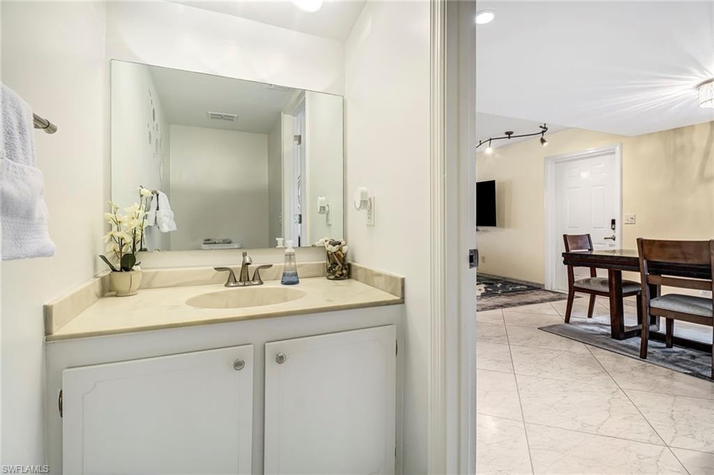 Bathroom featuring light marble finish floors and vanity