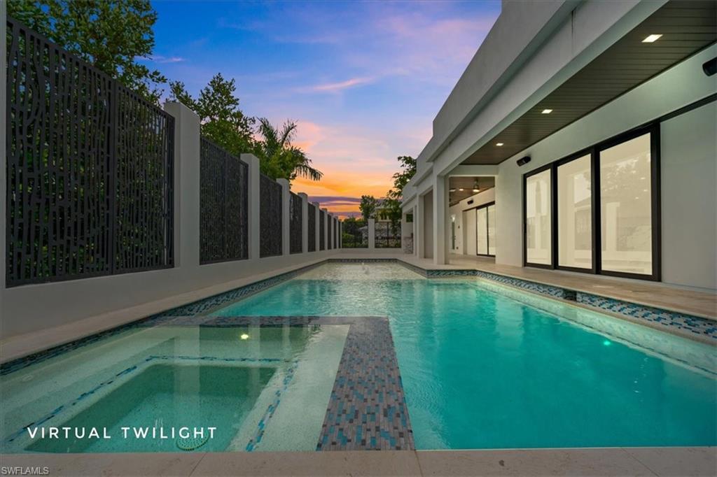 View of swimming pool featuring a patio area, a fenced backyard, and a pool with connected hot tub