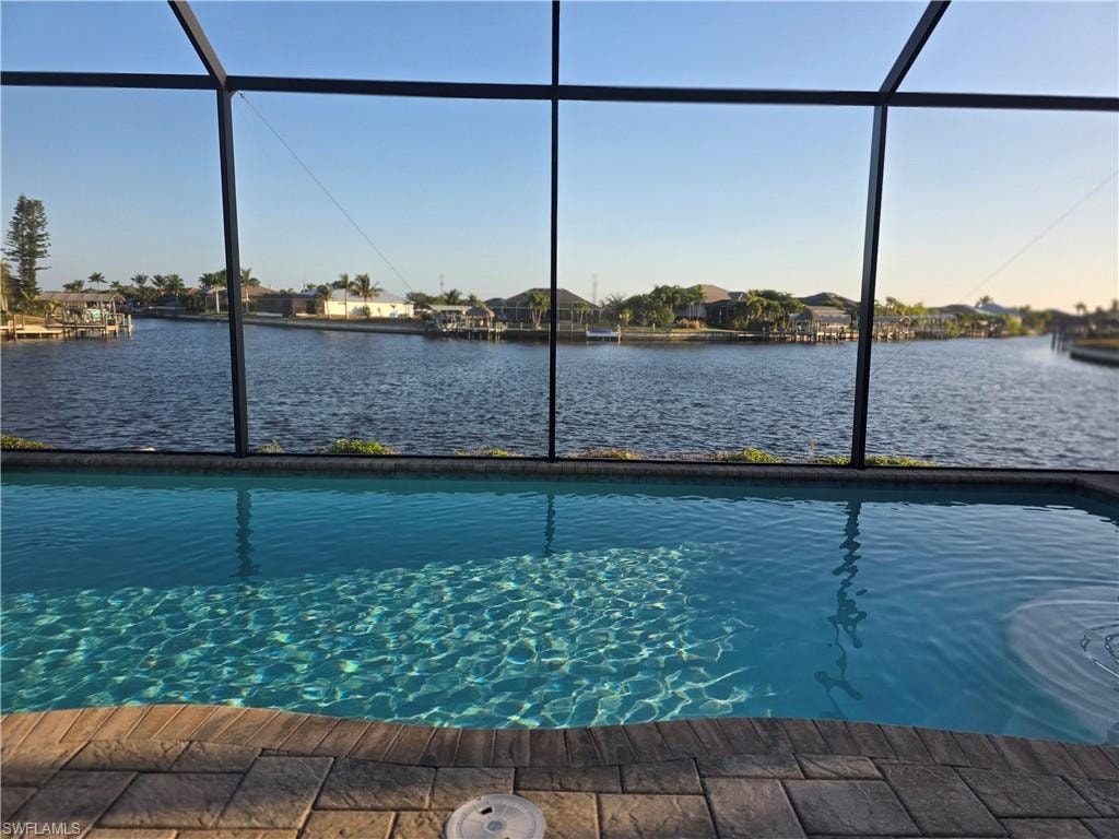 Swimming pool featuring a lanai, a sunroom, and a water view