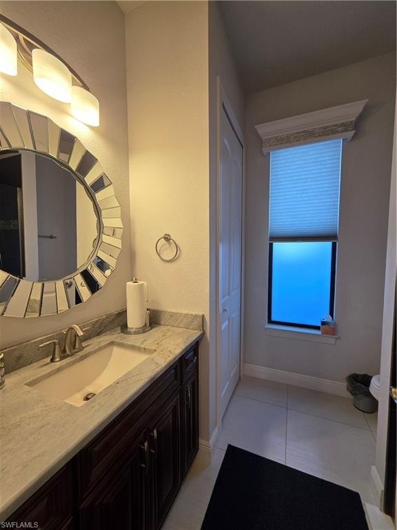 Bathroom featuring vanity, light tile patterned floors, and a closet