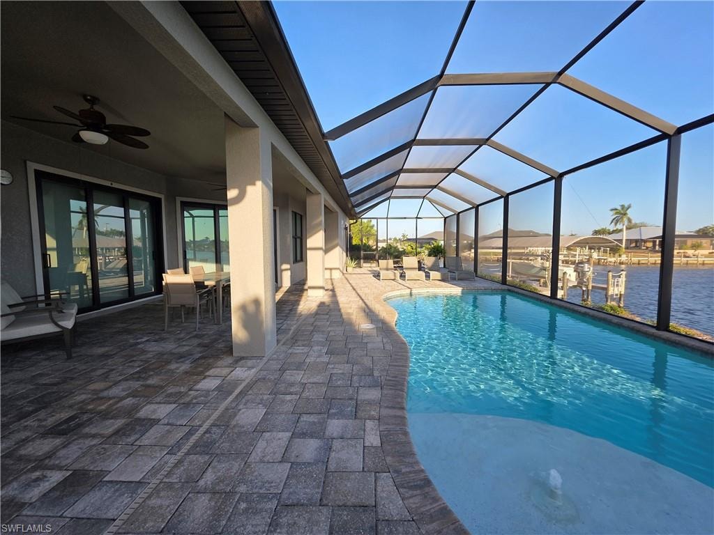 Swimming pool with a sunroom, a patio, outdoor dining area, and a lanai