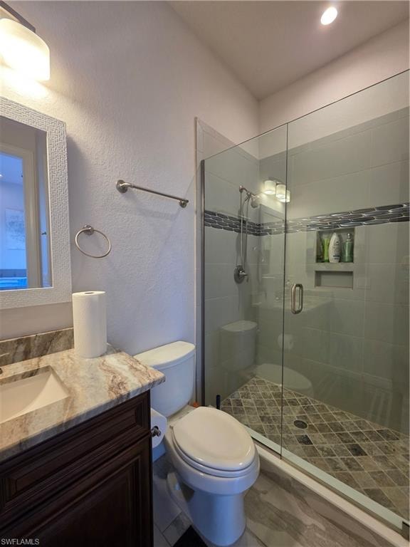 Full bathroom / Pool Bath featuring a textured wall, vanity, and a stall shower