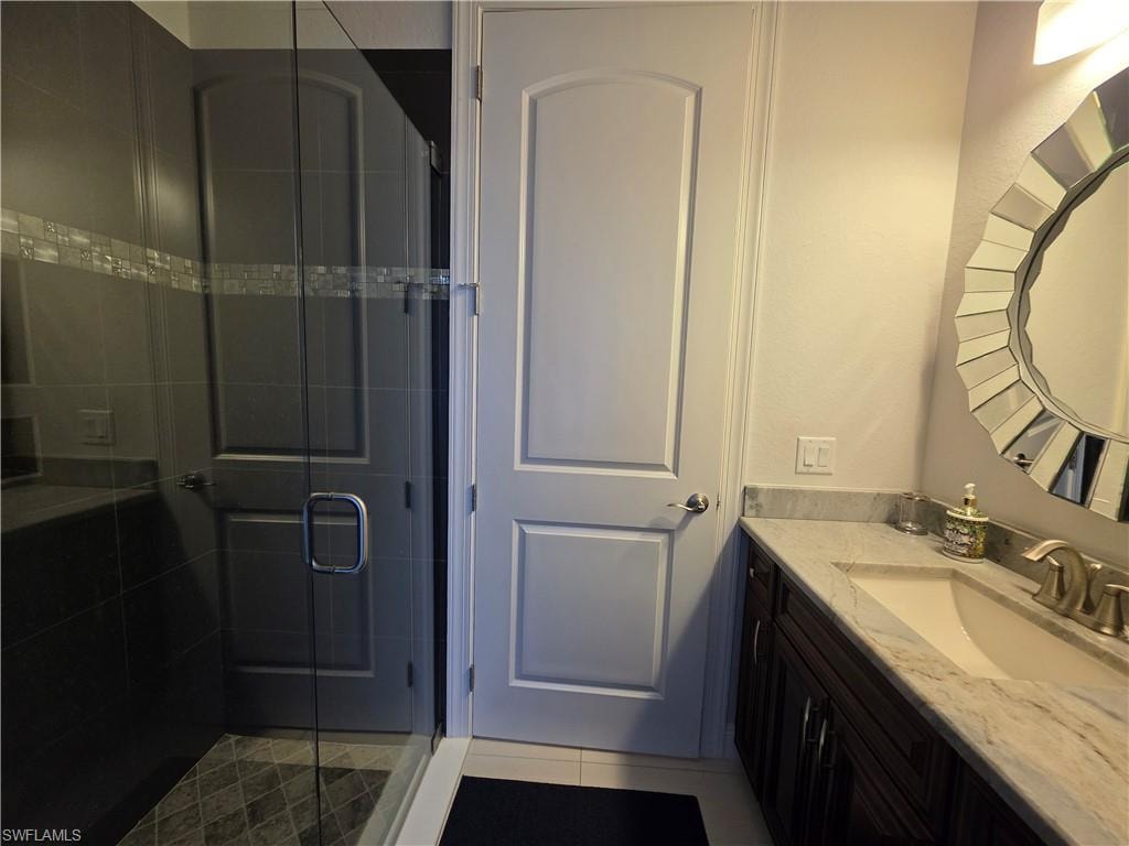 Full bathroom with vanity, a stall shower, and light tile patterned flooring