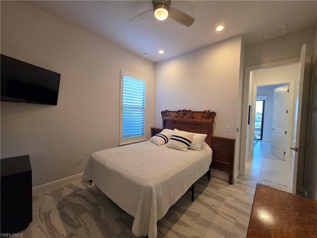 Bedroom with light marble finish flooring, a ceiling fan, recessed lighting, and multiple windows