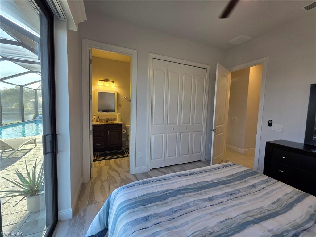 Bedroom featuring a closet, ensuite bath, and light wood-style floors