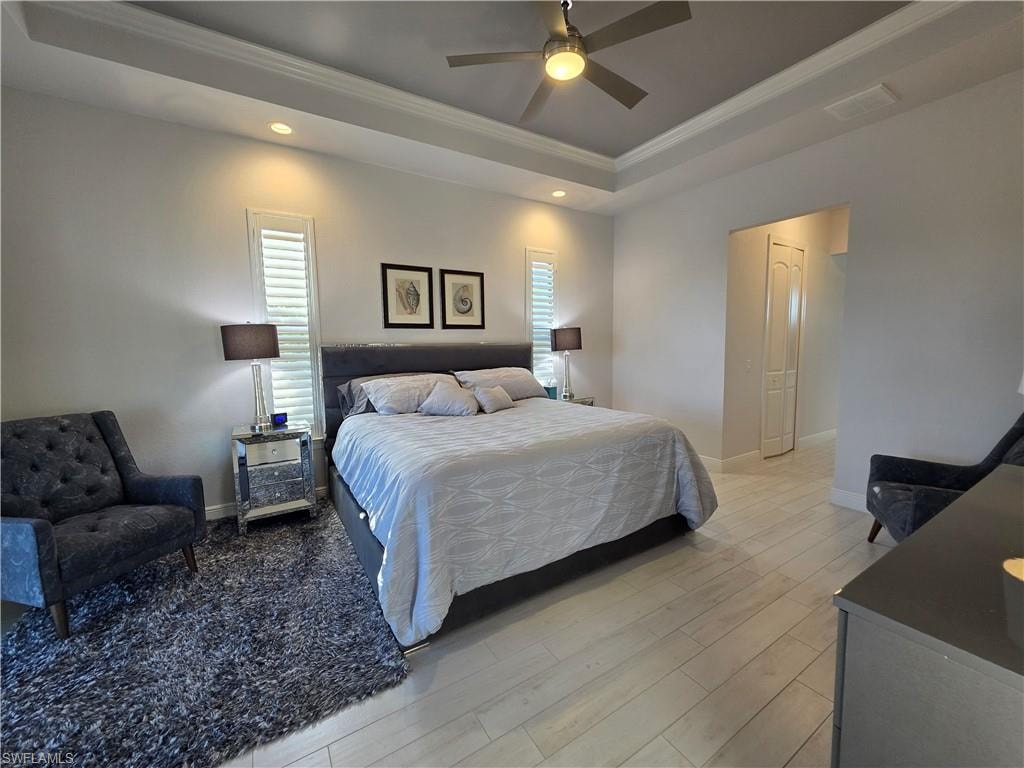 Bedroom featuring crown molding, multiple windows, wood finished floors, ceiling fan, and recessed lighting
