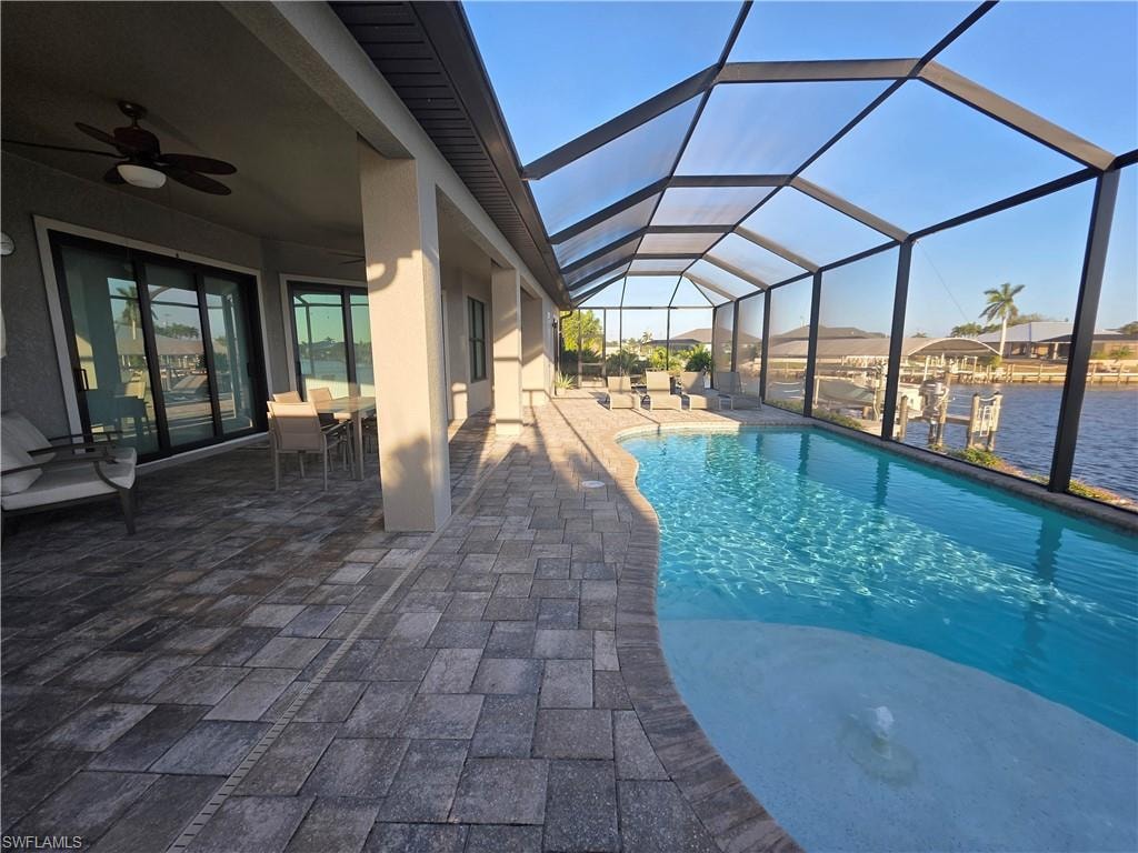 Swimming pool featuring a sunroom, a patio area, outdoor dining space, and a lanai