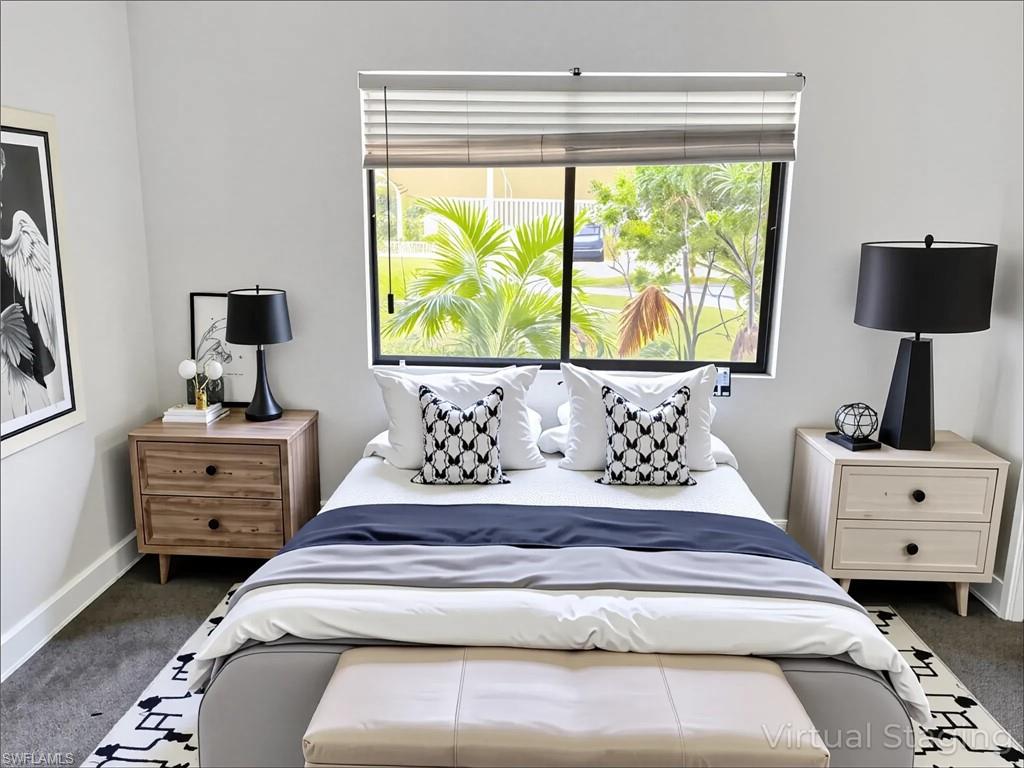 Bedroom with dark colored carpet and baseboards