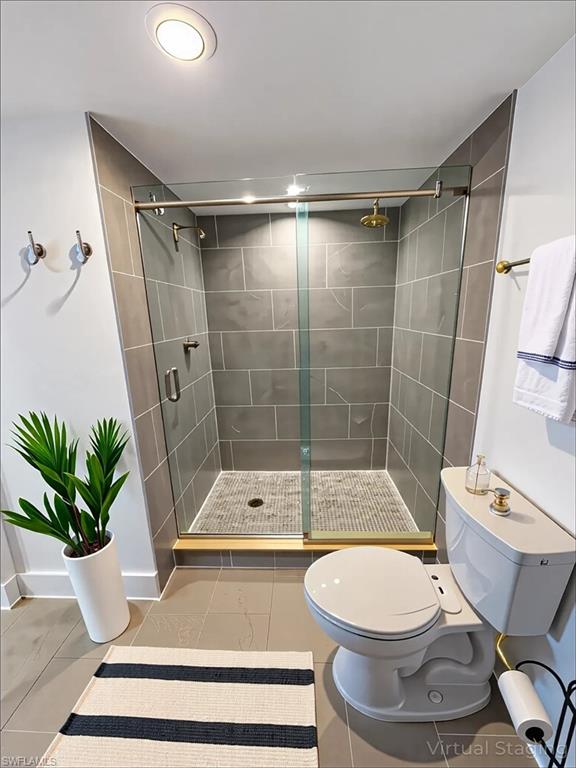 Bathroom featuring a shower stall and light tile patterned floors