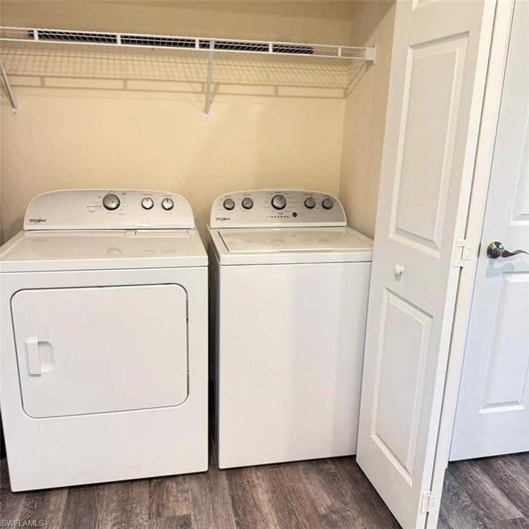 Laundry area featuring dark wood-type flooring and separate washer and dryer