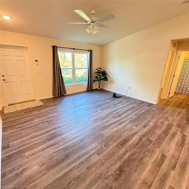 Unfurnished living room featuring wood finished floors and a ceiling fan